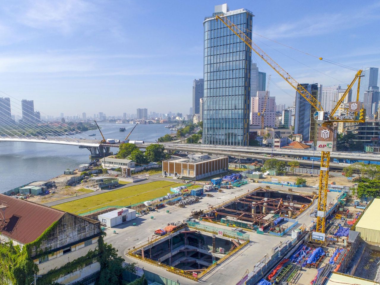 Aerial view of a deep basement excavation in Ho Chi Minh City next to the Saigon River and high-rise towers