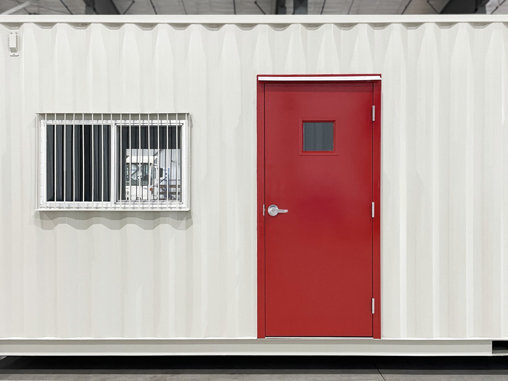 Red weld-in steel door in a converted shipping container
