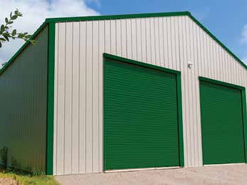 Green roll-up doors on a steel building